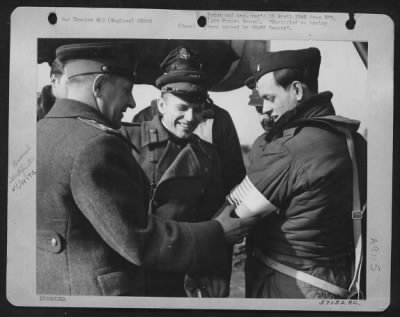 Thumbnail for Consolidated > East Meets West -- Fastening An American Flag Armband For Identification In Case Of A Forced Landing Behind The Russian Front, Colonel Fastovschut (Left) And Lt. Colonel Rudoi (Center) Both Of A Soviet Military Mission For Aviation, Wish 1St Lt. Francis E