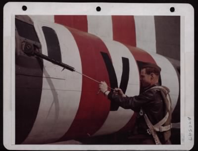 ␀ > S/Sgt. Howard Van Hoozer Of Girard, Kansas, Runs Patch Thru Barrel Of 50 Cal. Machine Gun. England.