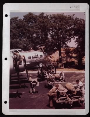 ␀ > Ground Crewmen Make A Final Check-Up As Ordnance Men 'Fin' 2000 Lb. Bombs Prior To Loading Into A Boeing B-17 At A Base In England.