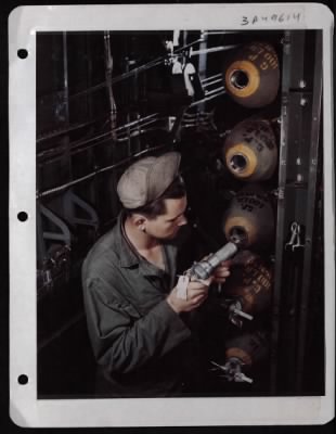 Thumbnail for ␀ > Pfc. Lenuel J. Putty Of Morton Gap, Ky., Inserts A Fuse Into A 100 Lb. Bomb Already In The Bomb Bay Of A Consolidated B-24.  England