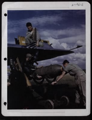 ␀ > Ordnance Men Push Bomb Under Plane'S Wing And Load Ammunition In The 50 Cal. Machine Guns. Arming Up Plane For A Mission Over France. S/Sgt. Robert E. Robinson, Syracuse, Ny, Rearms The Four 50 Cal. Machine Guns While M/Sgt. James H. Mcgee, Pine Bluff, Ar