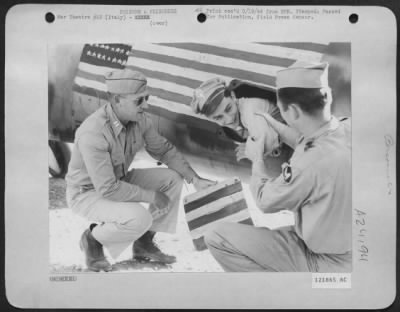 Consolidated > Capt. Fred Vickers (left) and Lt. James Huff (right) both officers in a B-24 Liberator Group of the 15th Air Force, watch Lt. Gerald W. Marshall of Los Angeles (center) demonstrate how Lt. Col. James A. Gunn, flew back from Bucharest, Rumania in a