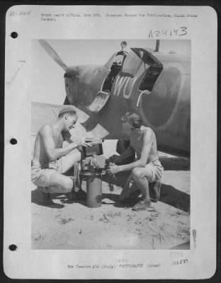 Thumbnail for Consolidated > These Two British Ground Crew Men Change The Magazine Of An Aerial Camera That Will Be Placed In The Fuselage Of A Spitfire That  'Spies' On Enemy Activity From The Air.  Italy