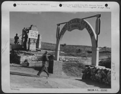 Thumbnail for Consolidated > Entrance To "Rocka Fella Center" M/Sgt. Charles A. Ballanger, New Bedford, Mass., Is Walking Toward The Entrance.  In The Background Is An Old Well That Is Used For Cooling Cokes And Beer, And Making Dream Wishes.  Italy.