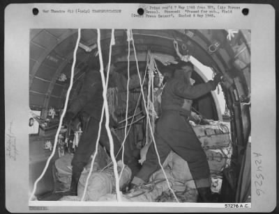 Thumbnail for Consolidated > Dropping Supplies To Italian Partisans -- The Douglas C-47 Is Nearing Its Destination, And The Crew Has The First Packages In The Hatchway, Ready To Kick Them Out At A Signal From The Pilot.  The Crew Works Without Parachutes Before The Open Hatchway For