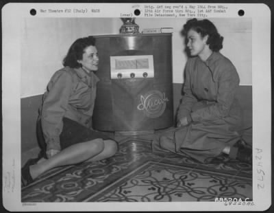 Thumbnail for Consolidated > Air Wacs Assigned To The 12Th Air Force Headquarters In Italy Listen To News From Home Via The Radio.  They Are, Left To Right: Pvt. Shirley E. Garrison Of Detroit, Michigan, And Pvt. Jean F. Moss Of Middlesborough, Kentucky.