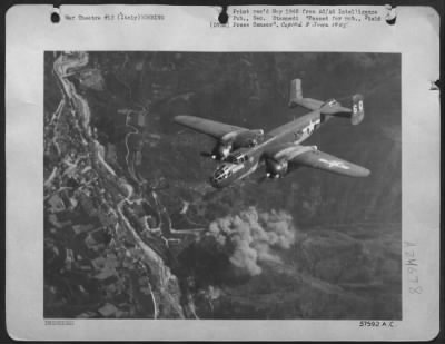 Thumbnail for Consolidated > Smoke Rises From The Strike Of The Bombs As The North American B-25 Mitchell Of The 12Th Af Pulls Out After Bombing A Germany Army Headquarters 25 Miles Northeast Of Verona, Italy.  One Building Was Destroyed And Three Seriously Damaged.