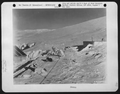 Thumbnail for General > Photo Shows To The Left Beachhead Building Built In 1942; To The Right, Powerhouse And In Center Foreground, Several Eskimo Dogs.  In The Background Is Ice Cap.  Notice Depth Of Snow That Has Already Fallen.  10 Oct 44.