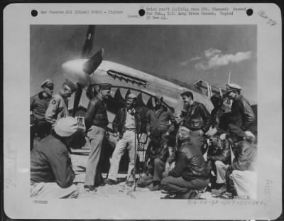 Fighter > Maj. Gen. C.L. Chennault, Commander of the 14th Air force, drops in at the line to chat informally beside a North American P-51, with some of his hard working, hard fighting pilots. Left to right, kneeling, are: Lt. Joel E. Beezley of St. James, Mo.