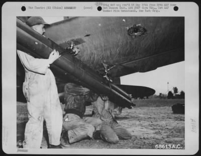 General > Men Tighten Nuts On The Braces Holding Rockets On The Wing Struts Of A Curtiss P-40 At An Airbase Somewhere In China.