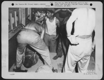 General > Shackling A 500 Lb. Bomb To Load It In A Boeing B-29 Of The 40Th Bomb Group, Xx Bomber Command, Before Taking Off For Mission 9 To Anshan, Manchuria.  Bomb Is Slung On Straps, Then Raised To Position By Two Hand Winches.  China.