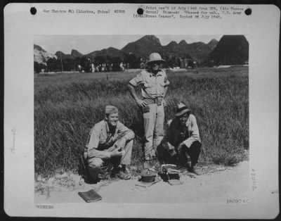 Thumbnail for Mines > Lt. Colonel Wright Hiatt, Winchester, Indiana, And Capt. Berwyn Fry, 7314 Bennett Ave., Chicago, Ill., Engineers With The 14Th A.F., And A Chinese Worker, With Two Of The Mines Removed From The Air Strip, At Liuchow, China.  The Former 14Th A.F. Base At L