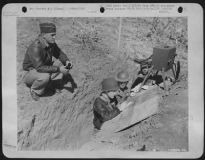 Thumbnail for General > SOMEWHERE IN THE U.S. ARMY 14TH AIR force IN CHINA. Maj. Gen. Claire L. Chennault Commanding General, U.S. Army 14th AF, directs operations at his command post during a Jap air raid over Chinese territory. Assisting him in the trench are