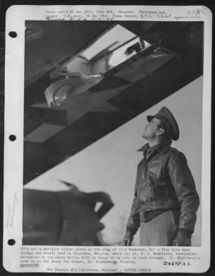 Battle Damage > It's not a skylight window shown on the wing of this Marauder, but a flak hole made during the recent raid on Chievres, Belgium, which 1st Lt. D.I. Simkinson, bombardier-navigator on the above Martin B-26 is happy to be able to look through.