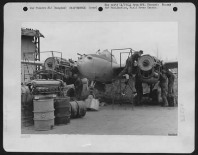 Thumbnail for Engines > 9th Air force mechanics pictured at work repairing engines ona P-38 Lightning fighter-bomber somewhere in Belgium. Working under adverse and variable conditions, ground crews and maintenance men are playing an important part in the air offensive