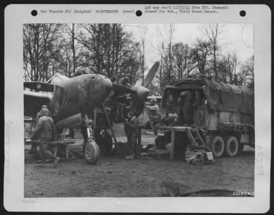 Thumbnail for Engines > 9th Air force maintenance men overhaul a Lockheed P-38 Lightning fighter-bomber at an airfield in Belgium. Working around the clock, often in the rain and cold, the ground crewman keep serviceable the planes that are eliminating or neutralizing enemy