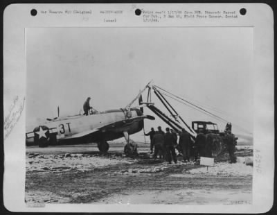 Thumbnail for General > A Ninth Air Service Command maintenance crew pulling a Republic P-47 out of the snow and mud of a base in Belgium for another mission against the enemy, a scene re-enacted numerous times during the critical days of the German advance.