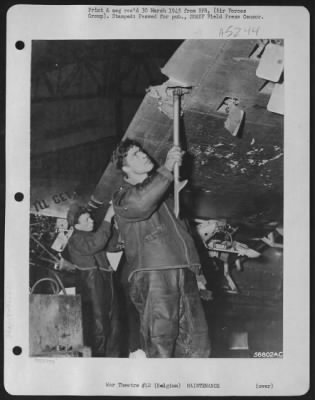 Thumbnail for General > Belgium-Ruefully examining part of the flak damage to the Republic P-47 Thunderbolt fighter-bomber "I'll Get By" is S/Sgt. Robert Rakow, Jr., 2116 S. 12th St., Sheboygan, Wis., while Pfc. Charles R. Eck, 511 Arlington Ave., Baltimore, Md., armorer