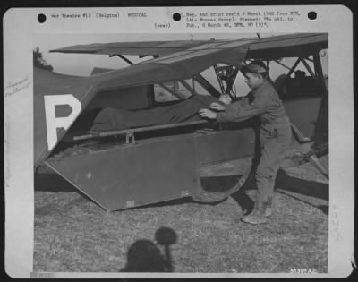 Thumbnail for General > BELGIUM--T/Sgt. James E. ofust, 666 Ankney Ave., Somerset, Pa., secures the litter in the rear of his Vultee L-5 before the take-off. He is one of the pilots now evacuating litter cases from the front lines to hospitals at the rear by plane.