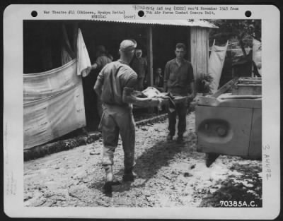 Thumbnail for Evacuation > A Patient Is Carried To The Receiving Station At The American Military Government Hospital Where Other Natives Are Waiting Their Turn To Be Treated By Personnel Of The Medical Unit On Okinawa, Ryukyu Retto.  15 June 1945.