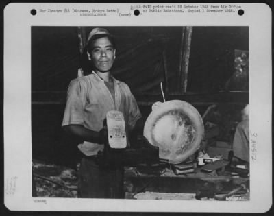 Thumbnail for General > Iron Shoes For Mi'Lady! - A Native Craftsman, Of Sorts, Shows Two Of The Objects Fashioned From Aluminum Scrap From Aircraft Destroyed In The War Three Years Ago.  The Object On The Left Is An Aluminum Shoe, Known As A Geta, While The One On The Right Is