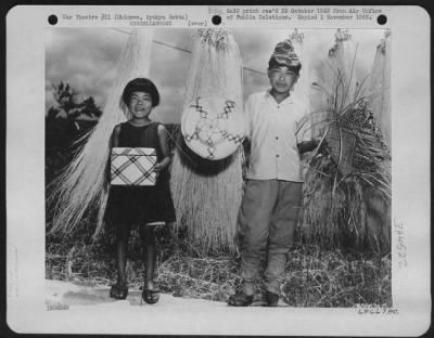 Thumbnail for General > Purses And Hats Woven In Shuri City - The Objects Hanging On The Line Are Not Grass Skirts, As Airmen Visiting The Southern Part Of Okinawa First Surmised, But Adamba Leaves, Bleached And Stripped Down For The Age-Old Weaving Of Purses And Hats, As Held B