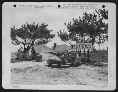 General > Men In Charge Of Operatons At An Airfield On Okinawa, Ryukyu Retto, Check Their Passenger Schedule.  Note The Carefully Revetted Headquarters In The Background.