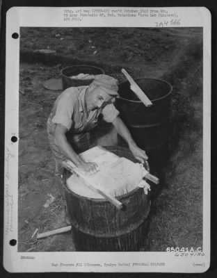 General > M/Sgt. Andrews Swadeba Does His Washing The Old-Fashioned Way.  He Finds That Fuel Drums Make Very Good Laundry Tubs.  Okinawa, Ryukyu Retto.