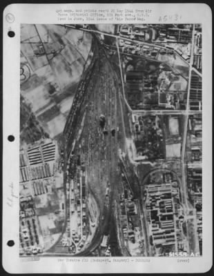 Thumbnail for Budapest > Budapest, Hungary. First bomb bursts in the center of rolling stock at a freight terminal record a bulls-eye for Army Air forces bombers in their initial attack on the Hungarian capital of Budapest. Adjacent oil refineries and the Tokol airdrome also