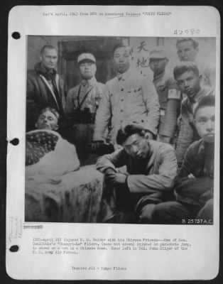 Thumbnail for General > Injured U.S. Raider with his Chinese Friends---One of Gen. Doolittle's "Shangri-La" Fliers, (name not known) injured in parachute jump, is shown on a cot in a Chinese home. Rear left is Col. John Hilger of the U.S. Army Air forces.