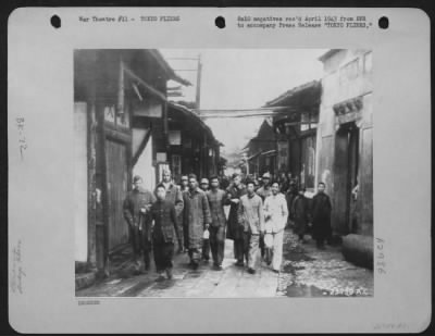 General > CHINESE AND AMERICAN COMRADES AT ARMS--Chinese soldiers bring in a group of Gen. Doolittle's Tokyo Raiders to the tiny village near where their bomber crashed. Center right, his arm held by a Chinese, is Col. John Hilger, who was injured.