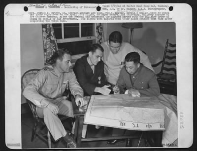 Ceremonies & Decorations > Capt. Harold F. Watson, Lt. Charles McClure and Capt. Ted W. Lawson, spread a man of Japan to point out their objectives on the April 18th flight, to Major General Chu Shih-Ming, Military Attache of the Chinese Embassy, after the General had