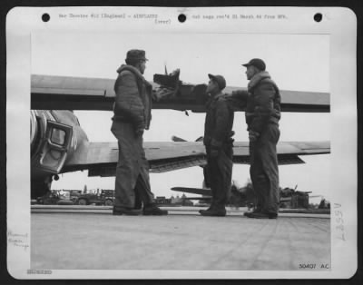 Thumbnail for Battle Damage > T/Sgt. Donald Grinell, 710 Vance St. Lansing, Mich., crew chief (in middle), examines damaged ofrtress with Sgt. James N. Sproules, Newark, N.J. (left) and Sgt. Julio Lopez, Tombstone Ariz., after return from today's raid on targets in Germany.