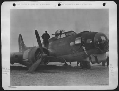 Battle Damage > FAIL OF "THE GI VIRGIN"--Sgt. Thomas Muse, Palestine, Texas, member of engineering staff stands on ofrt wing inspecting damage done to ship when it came in with no brakes and as pilot said, "groundlooped" to a landing. The landing gear collapsed