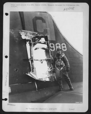 Thumbnail for Battle Damage > S/Sgt. Charles A. Haywood, 27, Weatherofrd, Okla., tail gunner on the U.S. Army 8th Air force Boeing B-17 Flying ofrtress "Lace's Aces", stands beside the 3 by 6 ft. hole torn in the tail of his ship by 20 mm shells that barely missed his head