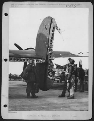 Thumbnail for Battle Damage > Crew members of a Consolidated B-24 Liberator which returned from pre-invasion bombing of French coast 20 April 44 with severe flak damage inspect tail assembly. The direct flak hit wrecked the tail turret and killed the tail gunner. Observers