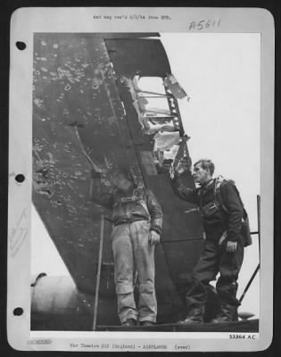 Thumbnail for Battle Damage > The flak torn wing of the Consolidated B-24 Liberator "Glass House" is inspected by the pilot (fight) 1st Lt. Louis Novotny, Wilberton, Okla., and the co-pilot 2nd Lt. Robert A. Olson, 1008 Caledonia , St., Butte, Mont., after their return from a