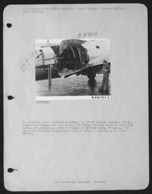 Battle Damage > The co-pilot, 2d Lt. Winfield F. Muffet, 22, of 195 Euclid, Pasadena, Calif., examines the damage done to a Boeing B-17 Flying ofrtress caused by flak after bombing the marshalling yards at Cologne in the Ruhr Valley 27 Sep 44. The top of the