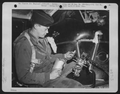 Thumbnail for Battle Damage > Lt. J.E. Mclain, Pueblo, Colorado, Bombardier On The Boeing B-17 "Flying Fortress" Bomber, 'The Monitor', Looks Over The Chin Turret Gun Controls That Were Smashed By Flak Entering The Ship Through The Plexi-Glass Nose.  The Hoses Were Blocked On The Way