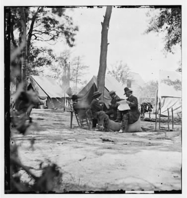 Thumbnail for 2885 - Gen. Ambrose E. Burnside (reading newspaper) with Mathew B. Brady (nearest tree) at Army of the Potomac headquarters