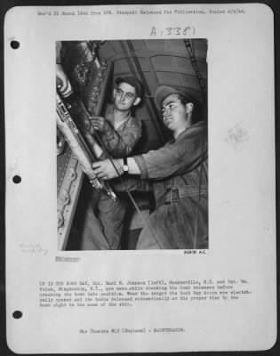 General > UP IN THE BOMB BAY, Cpl. Earl H. Johnson (left), McAdenville, N.C. and Sgt. Wm. Polak, Binghamton, N.Y., are meanwhile checking the bomb releases before cranking the bomb into position. Over the target the bomb bay doors