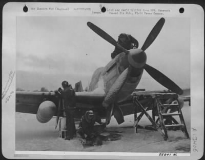 General > Winter's icy grip makes the crewmen's work difficult at this U.S. 8th Air force fighter base, but the show goes on as skilled mechanics ready the speedy planes for take off--on time: Shortly after the picture was taken, the Mustangs from the 55th