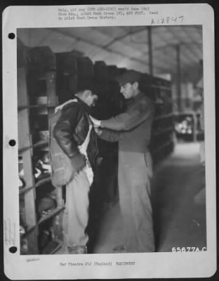 General > Sgt. Charles R. Warble Helps Lt. John Evans, Navigator On A Boeing B-17 "Flying Fortress" Of The 401St Bomb Group, Don His Parachute, Flak Suit, Mae West, Etc.  England, 9 April 1944.