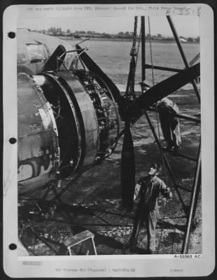 Propellers > The ground crew men ease the propeller on to its shaft as it hangs from the hoist. ENGLAND