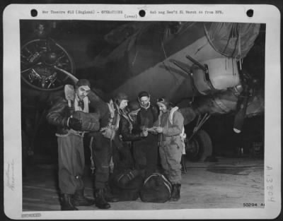 Thumbnail for General > Combat crewmen make final check-up of personal equipment and discuss points brought out during the briefing. The bombers nose is covered with a tailored tarpaulin to keep the plexiglass clear of frost which might obscure the pilot's vision. The