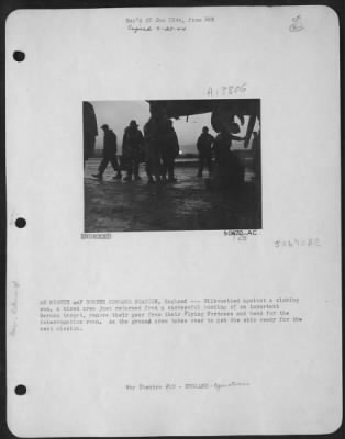 General > AN EIGHTH AAF BOMBER COMMAND STATION, England---Silhouetted against a sinking sun, a tired crew just returned from a successful bombing of an important German target, remove their gear from their Flying ofrtress and head for the interrogation room.