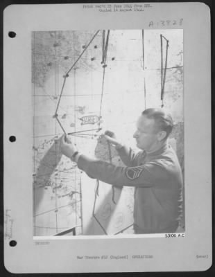 General > S/Sgt. Kenneth Johns of Elyria, Ohio, a bomber group intelligence clerk, stretches black yarn marking across the Channel route prior to briefing of combat crews at an 8th Air force base in England.