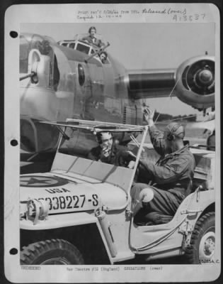 Thumbnail for General > ENGLAND. Directing a Consolidated B-24 Liberator to the runway for a takeoff is the control jeep manned by Corporal Larry Roth, 2279 McDonald Avenue, Brooklyn, New York and Corporal Wallace E. Merquardt, Fremont, Wisconsin. Both men are members