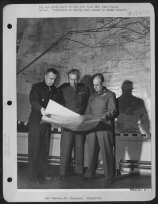 Thumbnail for General > The Commanding General of the U.S. 8th AF, Lt. General James Doolittle, looks over a weather map with two members of his staff. Standing in front of the route map of a Berlin mission, Gen. Doolittle confers with Brig. Gen. Charles Y. Banfill