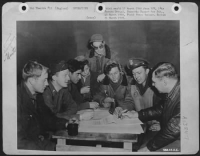 General > After completing bombing mission to dock installations at Swinemunde, Germany in support of Russian land drive on Eastern Front, crew members of the 448th Bomb Grp. Consolidated B-24 Liberator "Jokers Wild," are interrogated by intelligence officers